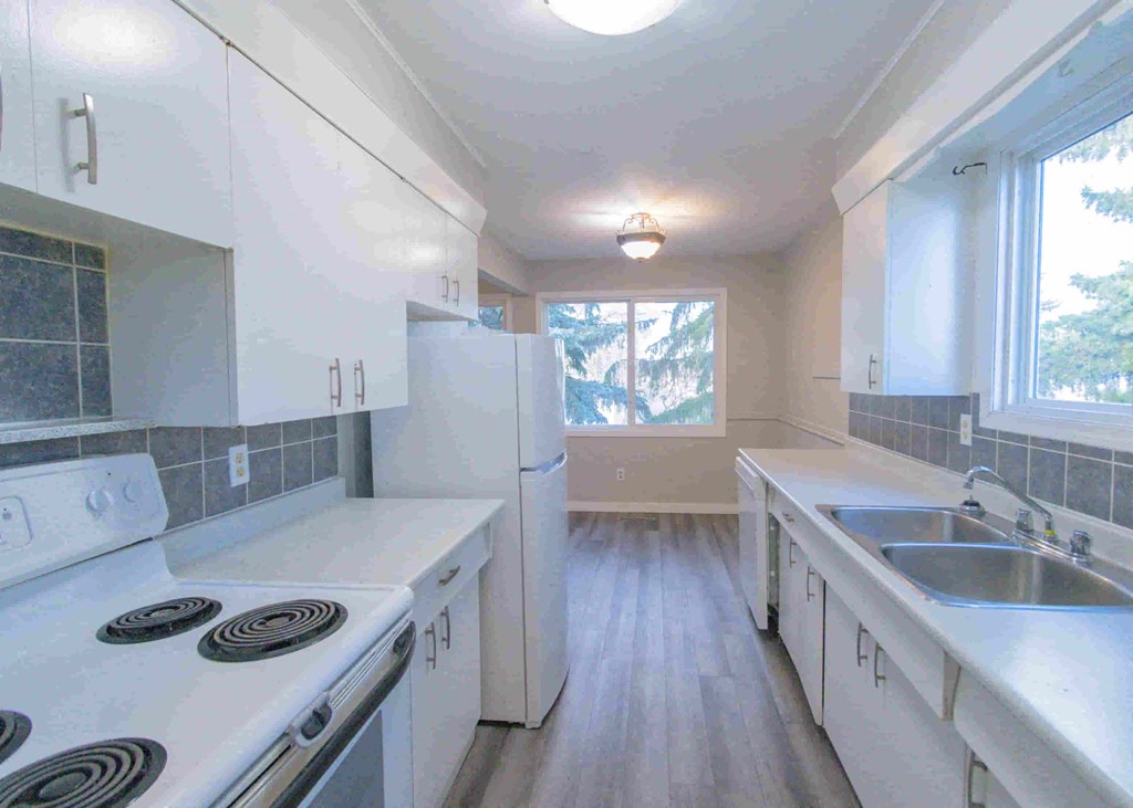 a kitchen with white cabinets and a sink and a refrigerator