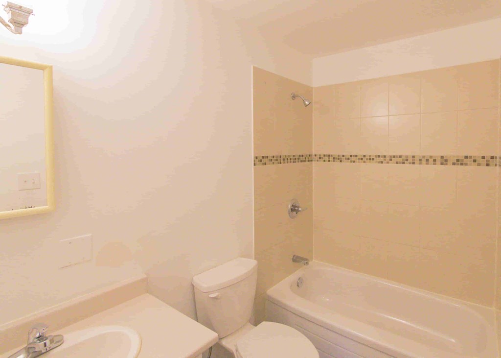 a bathroom with a toilet and a tub and a sink