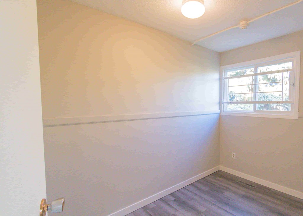 an empty room with white walls and a window