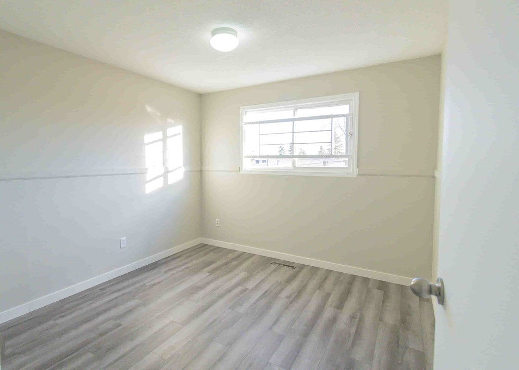 an empty room with white walls and a window