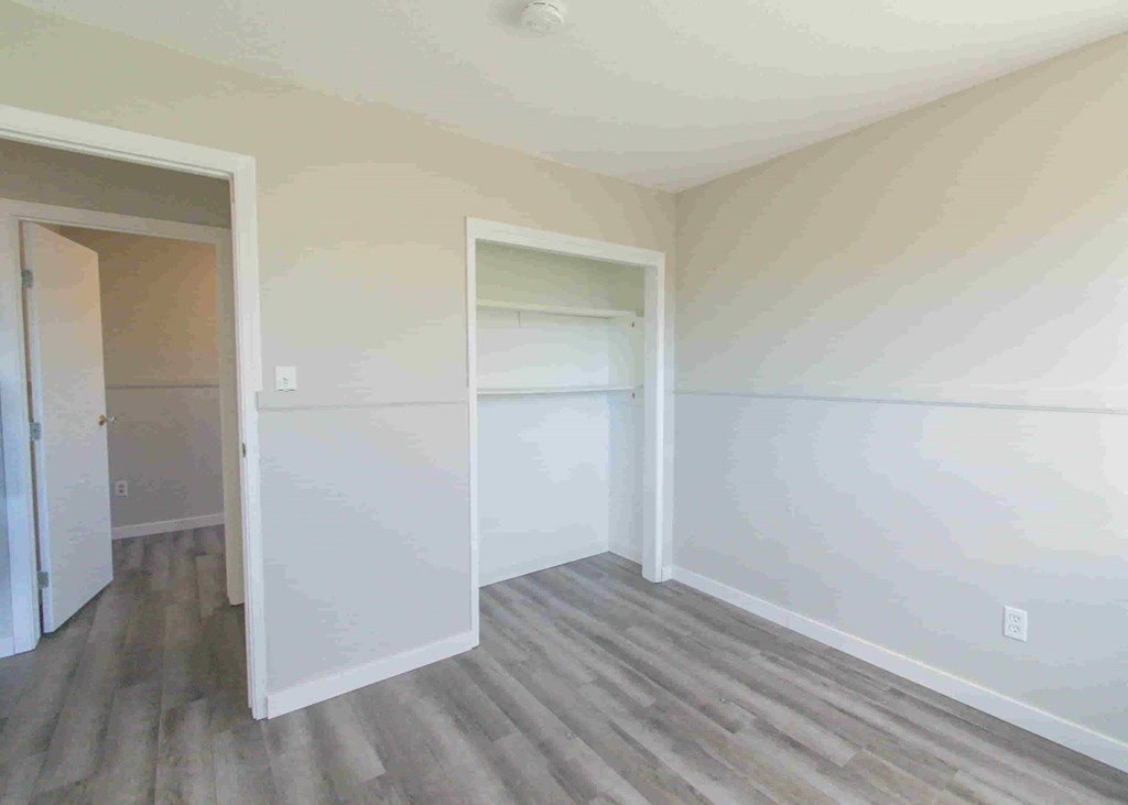 an empty room with white walls and a closet