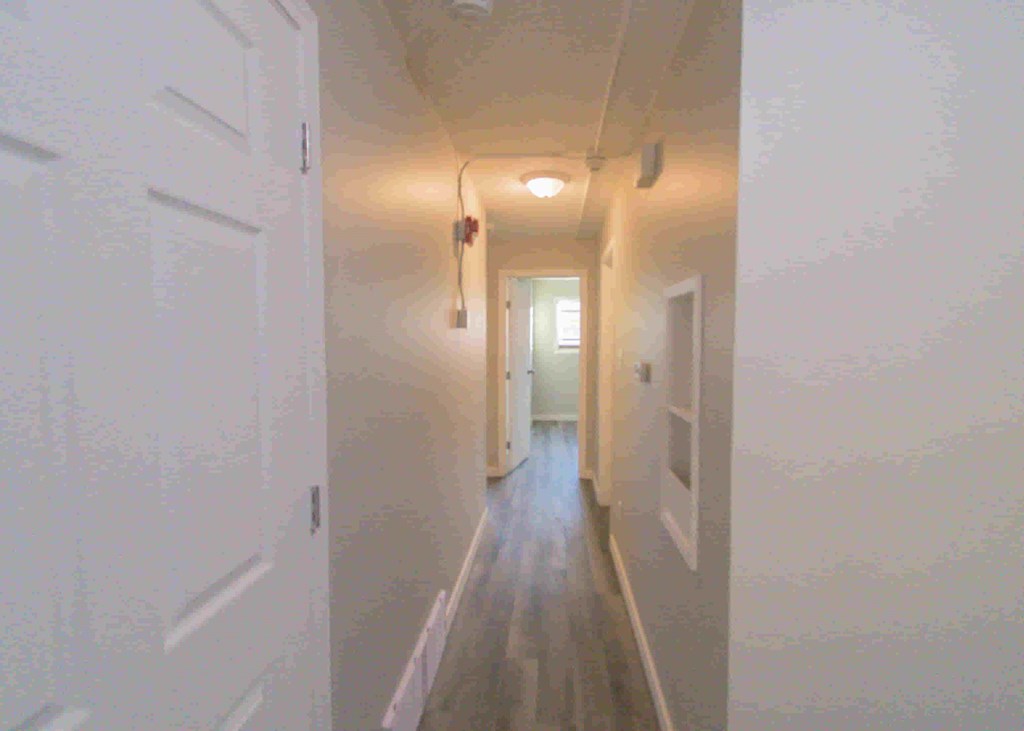 a long hallway with white doors and a light on the ceiling