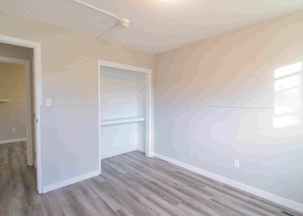an empty room with white walls and a door to a closet