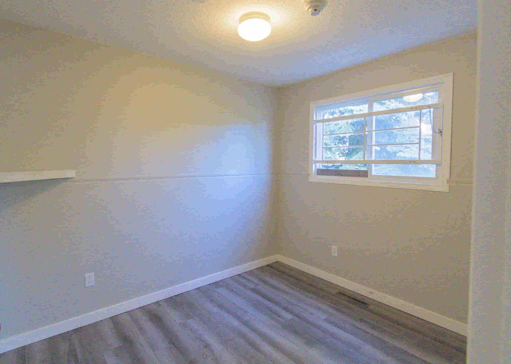 an empty room with white walls and a window