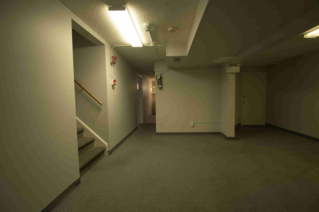 a hallway in a building with white walls and stairs