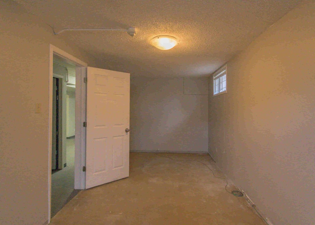 an empty room with a door and a light on the ceiling