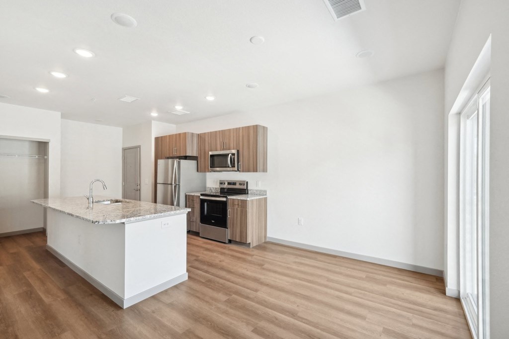 a white kitchen with a marble counter top and