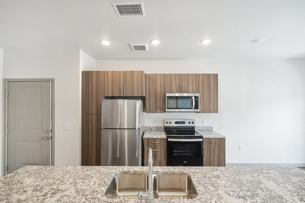 a kitchen with a granite counter top and a stainless steel refrigerator