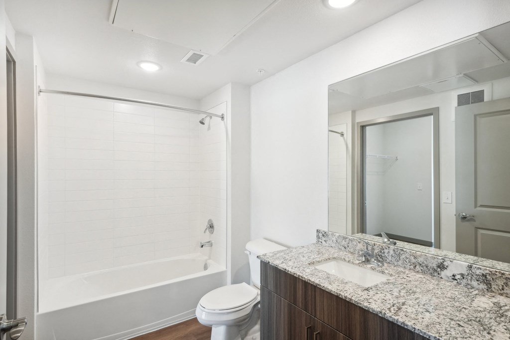 a bathroom with a shower sink and toilet and a mirror