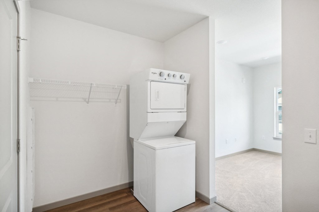 an empty laundry room with a washer and dryer in it