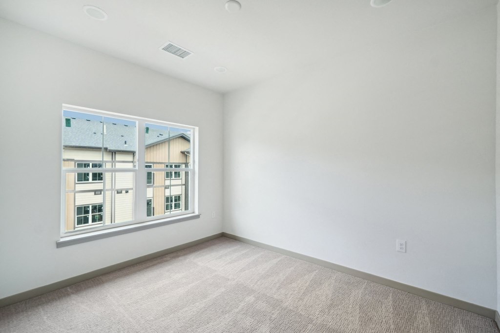 a bedroom with a large window and white walls