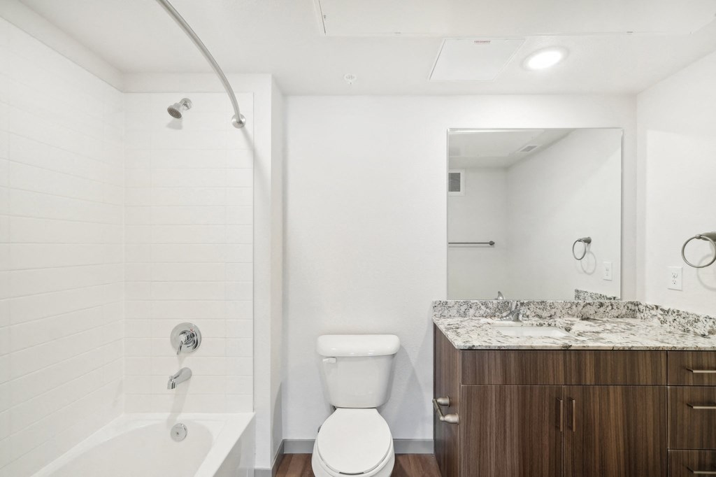 a bathroom with a toilet sink and shower and a mirror