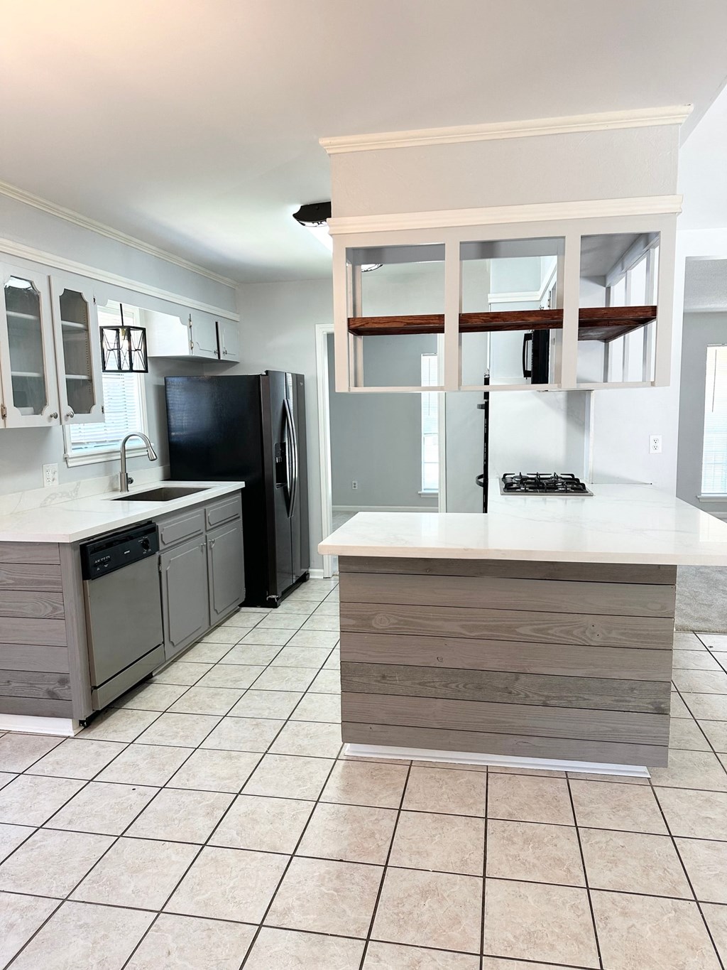 a kitchen with a large island and a black refrigerator