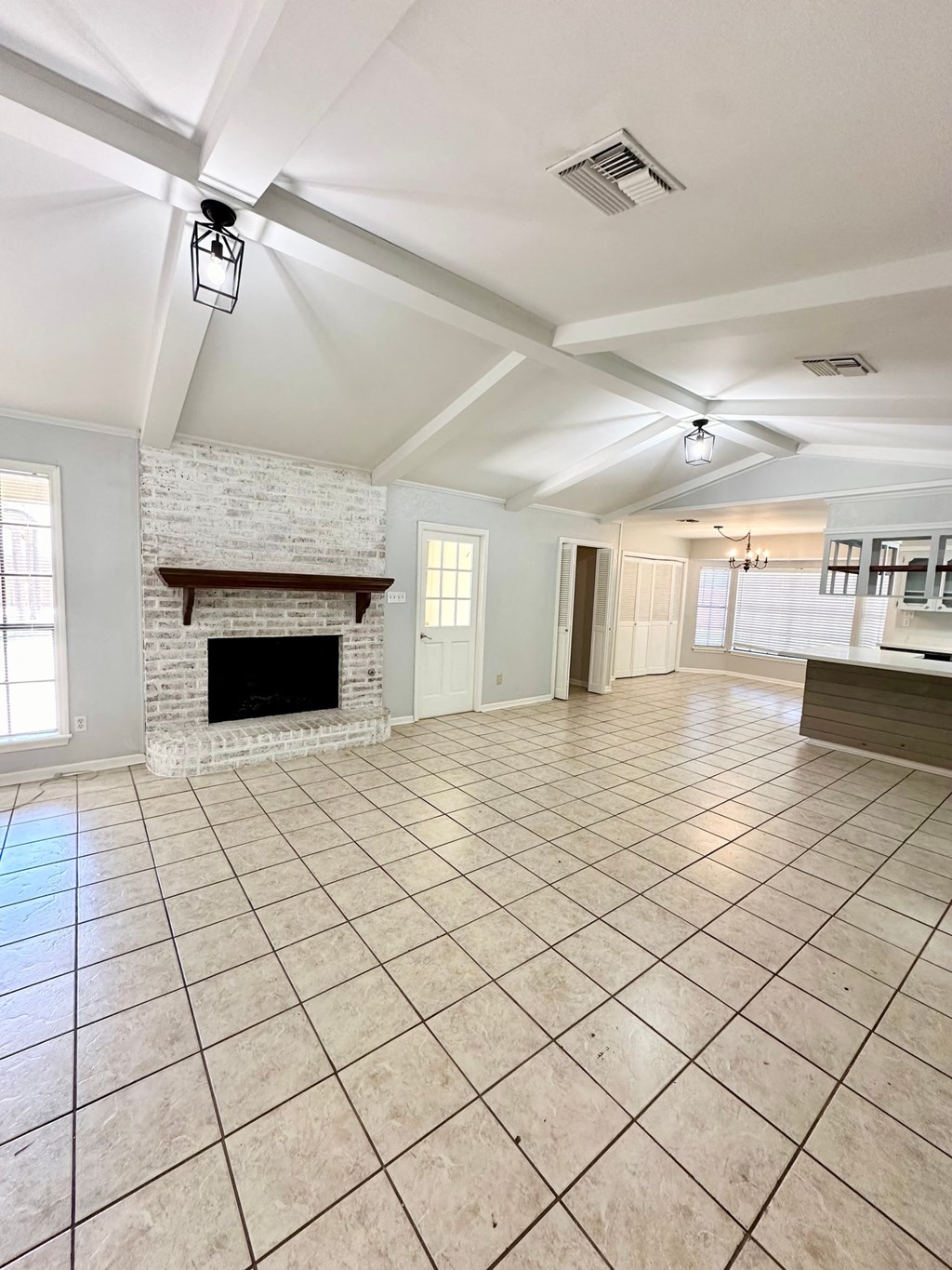 a large living room with a fireplace and tile flooring