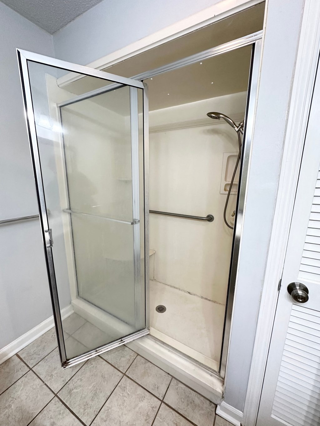 a shower with a glass door in a bathroom