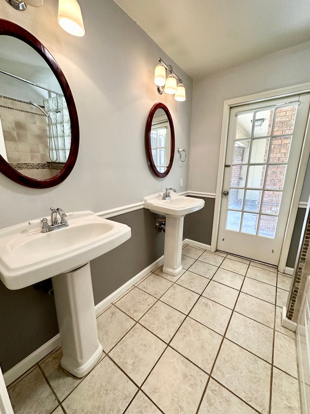 a bathroom with two sinks and two mirrors