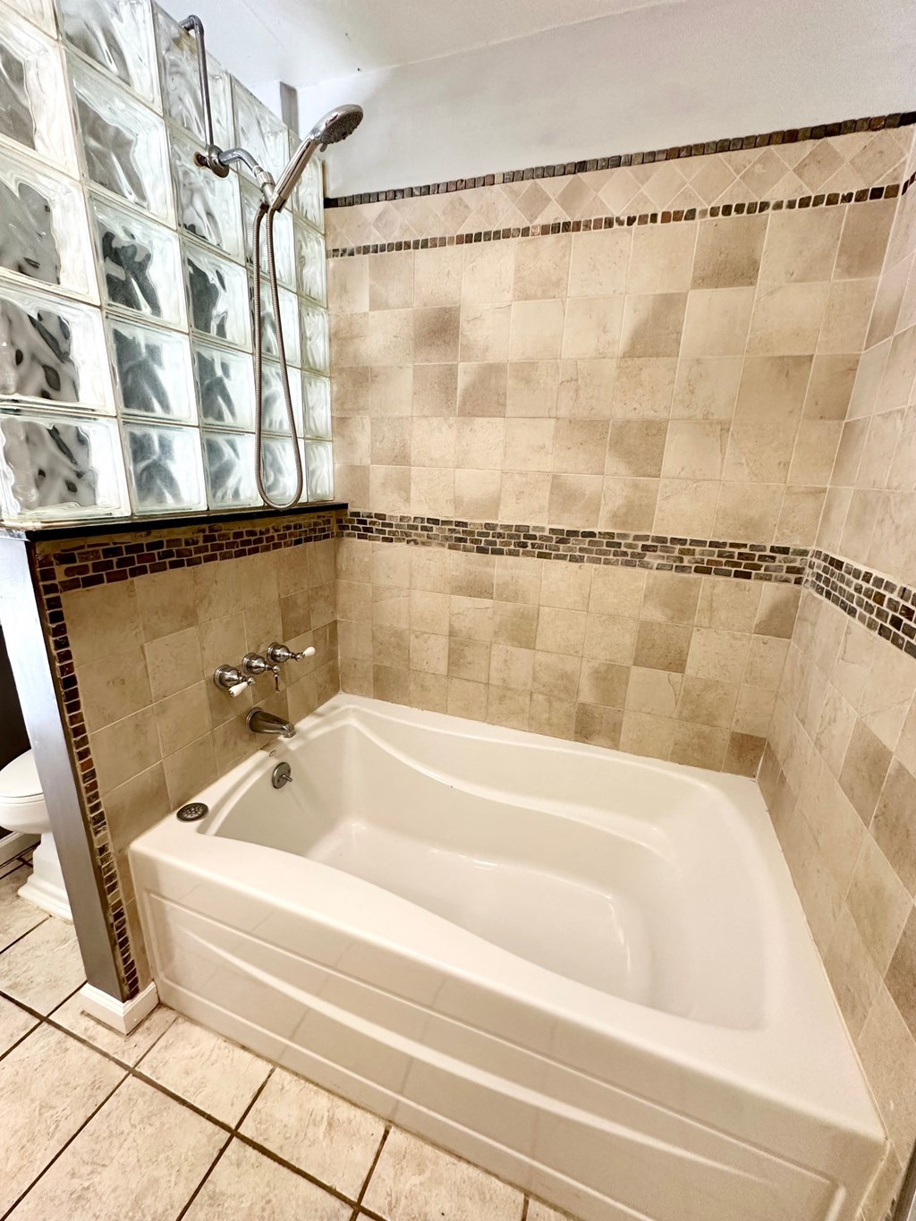 a large white bath tub in a tiled bathroom