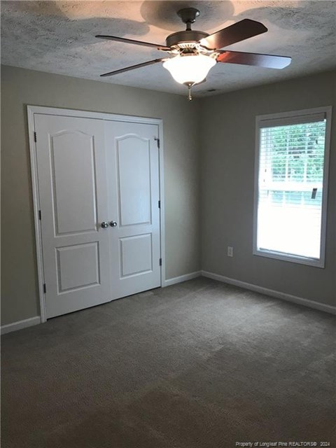 A room with a ceiling fan and two doors.