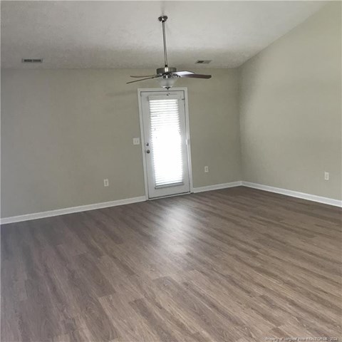 A room with a ceiling fan and a door with blinds.