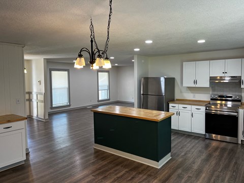 a kitchen with white cabinets and a black counter top