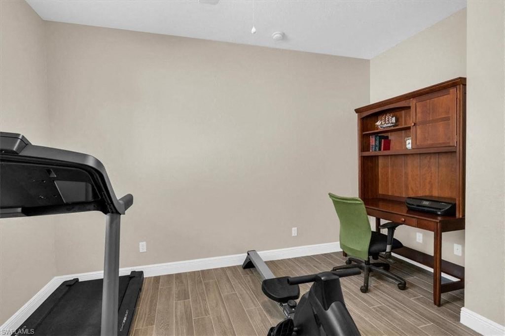 a home gym with a desk and a chair in a room