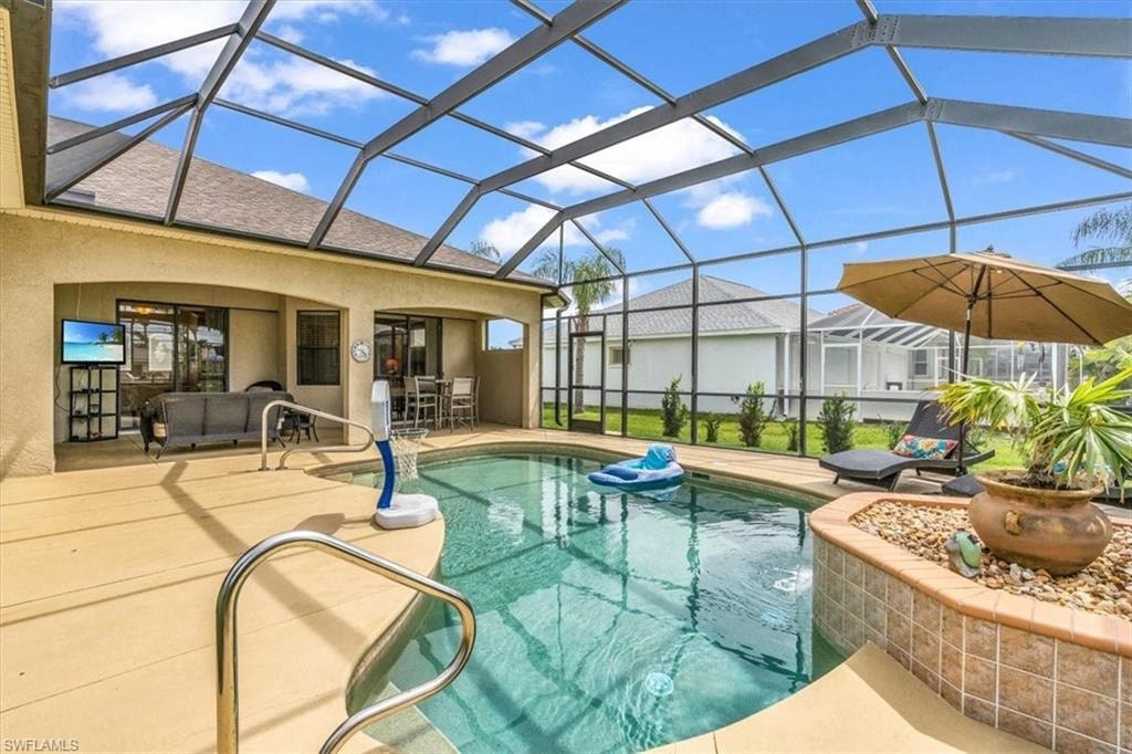 a swimming pool with an umbrella in a house with a glass roof