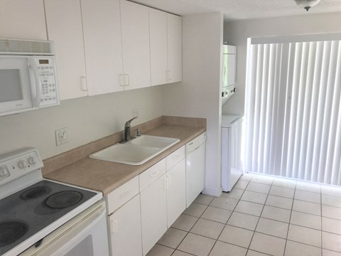 a kitchen with white cabinets and a sink and a stove