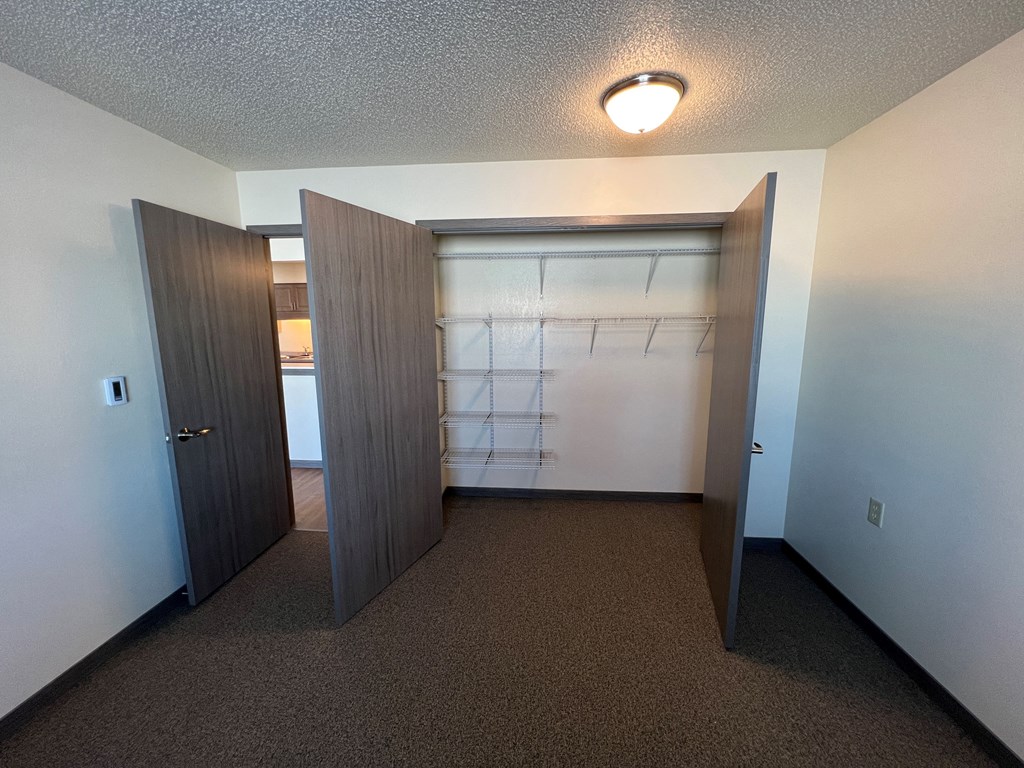 an empty room with a closet and a door to a bathroom