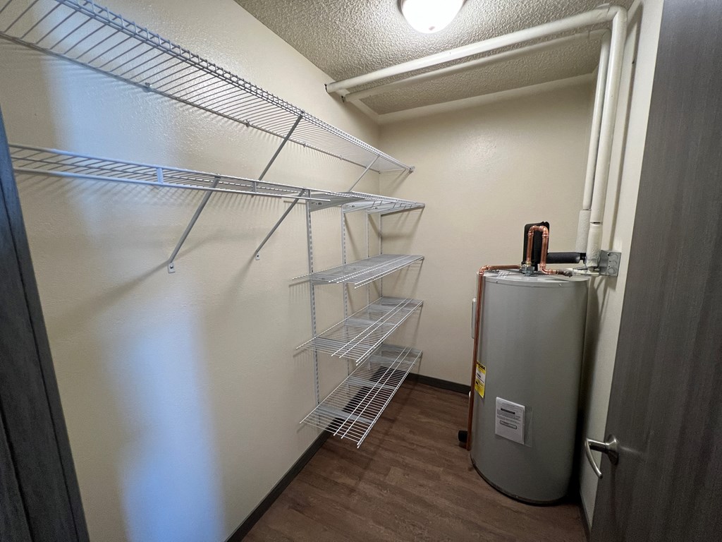 a walk in closet with a refrigerator and shelves in a room