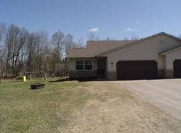 A house with a garage and a driveway in front.