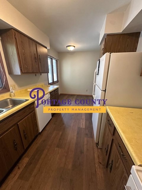 A kitchen with wooden cabinets and a white refrigerator.