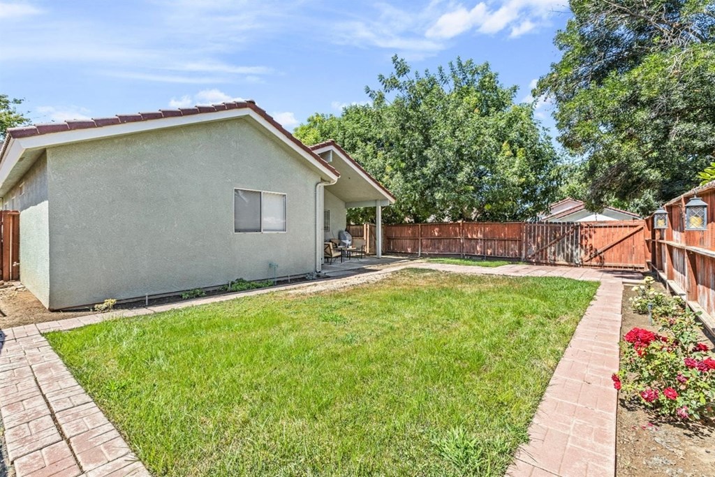 the backyard of a house with a yard and a fence