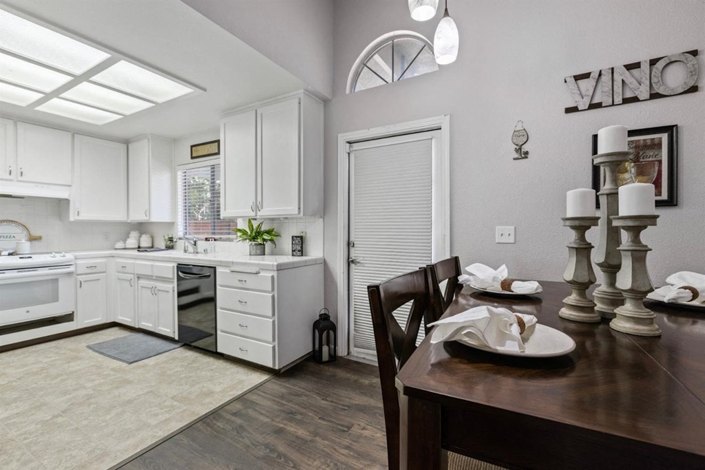 a kitchen and dining room with white cabinets and a table