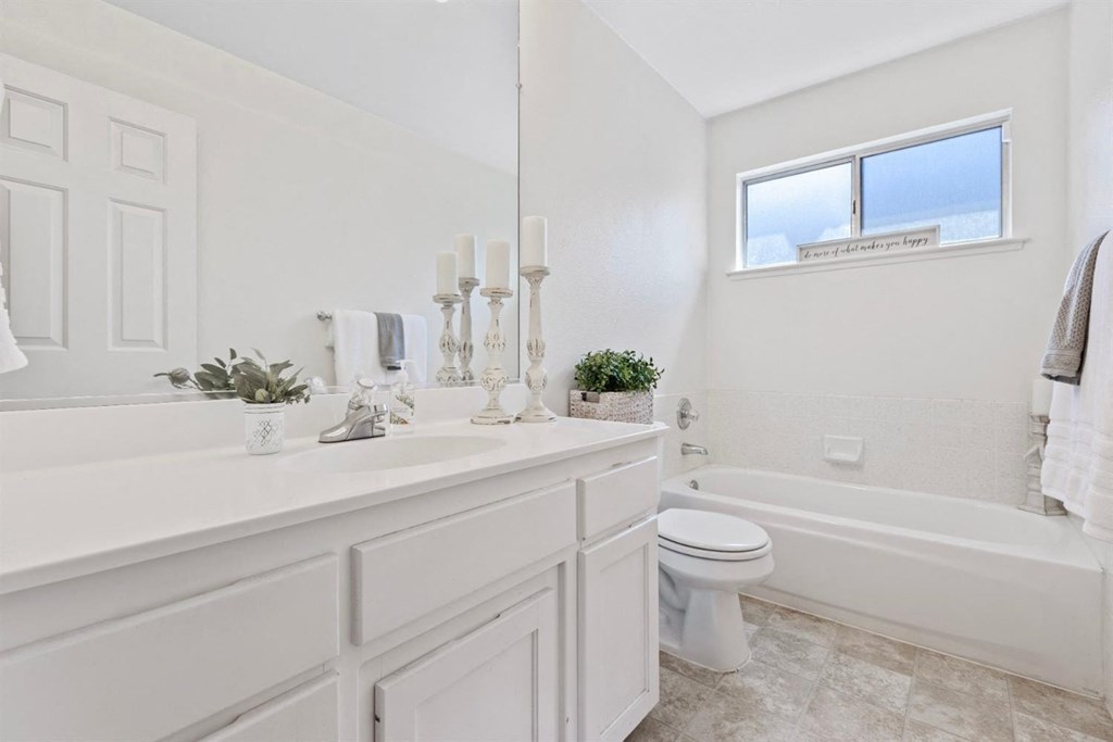 a white bathroom with a toilet and a sink