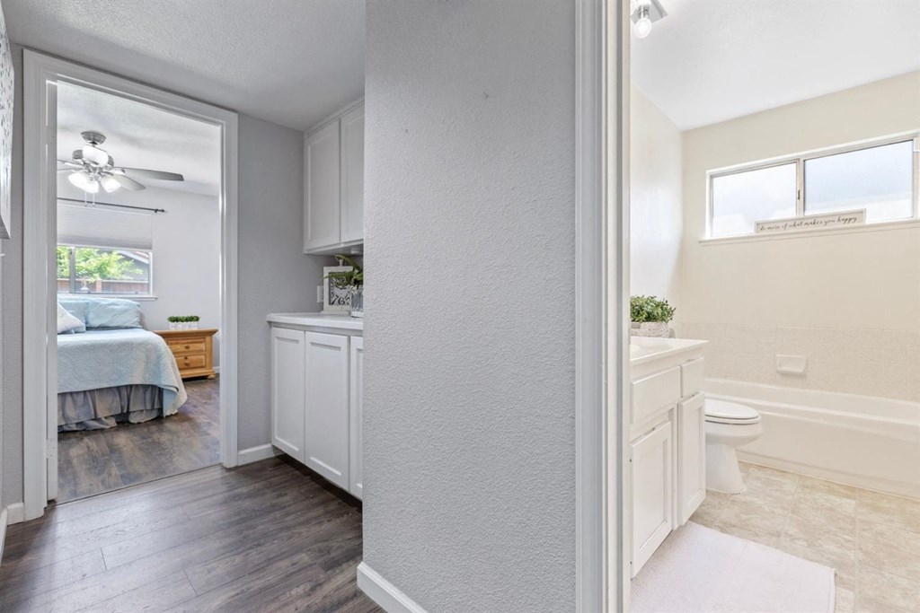 an open bathroom with a bedroom in the background and a toilet