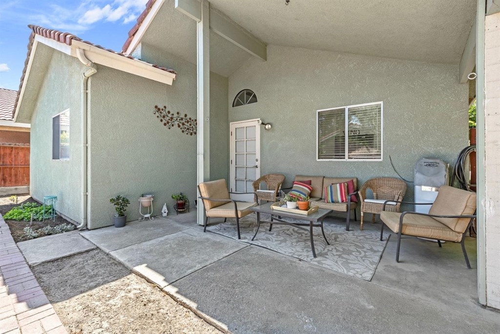 a patio in front of a house with a table and chairs