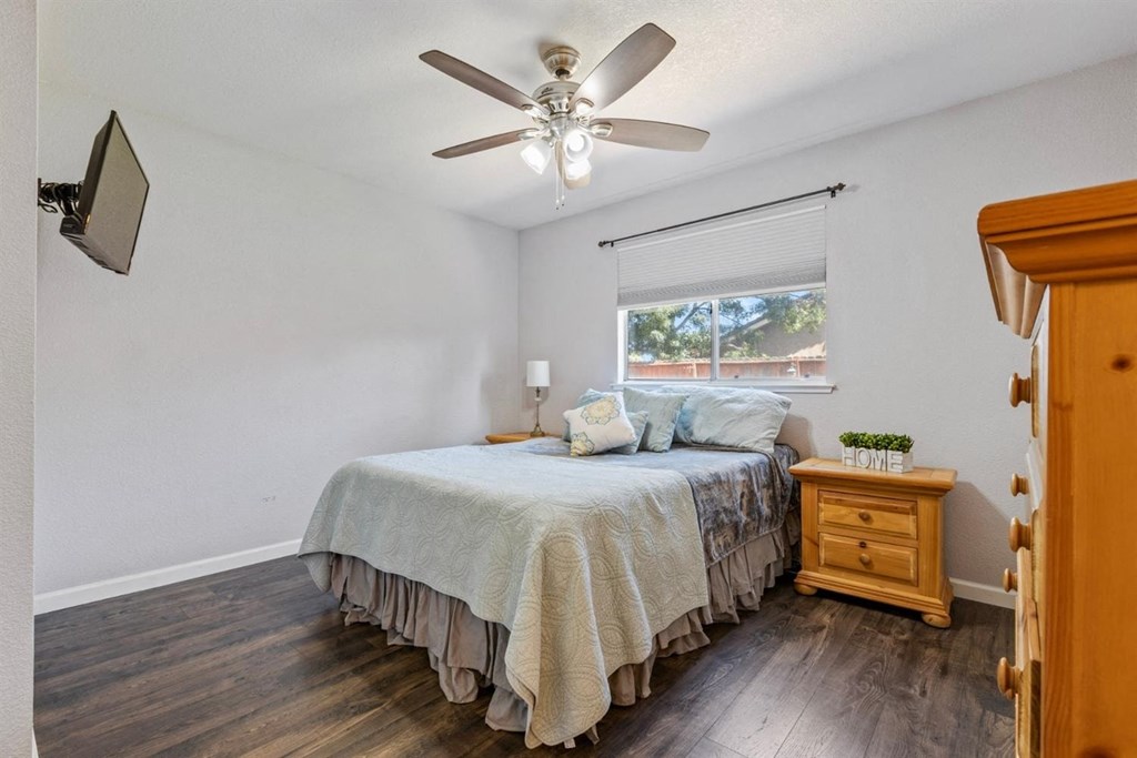 a bedroom with a bed and a ceiling fan