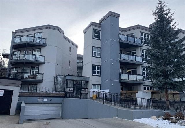 an apartment building with a tree in front of it