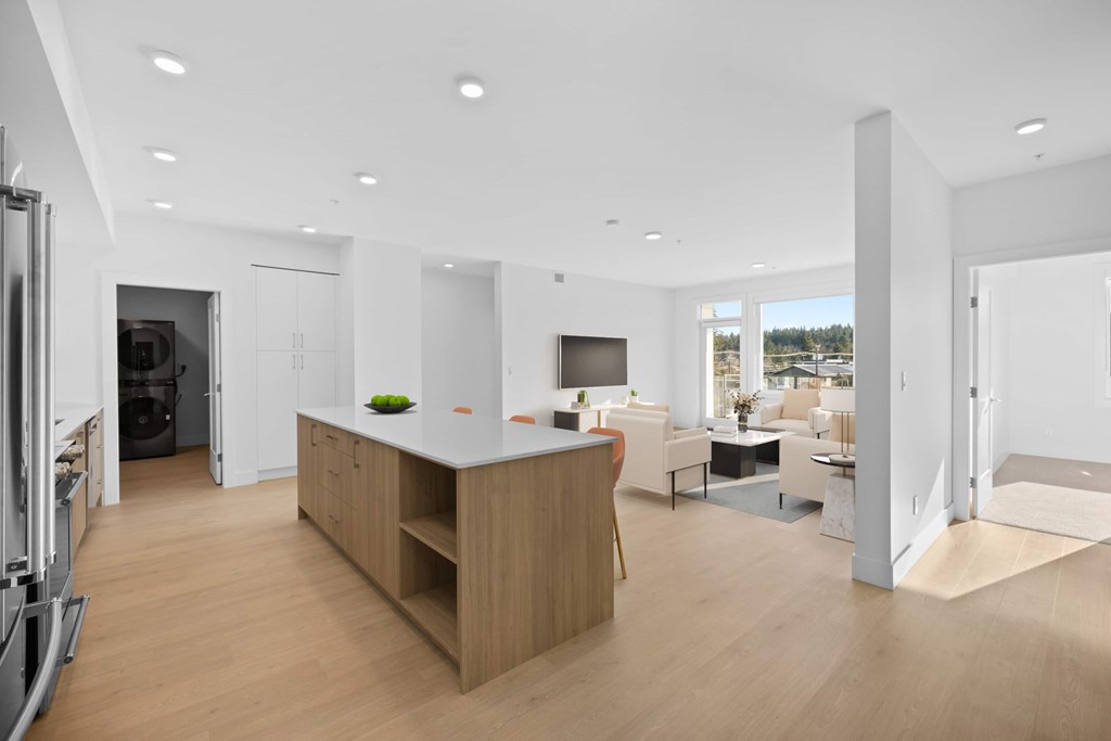 A modern kitchen with a wooden island and a dining area with a table and chairs.