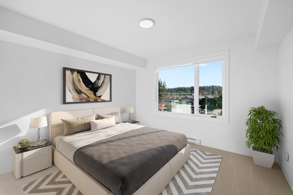 A bedroom with a large bed and a view of the outside through a window.
