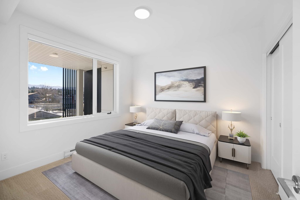 A bedroom with a large bed and a painting on the wall.