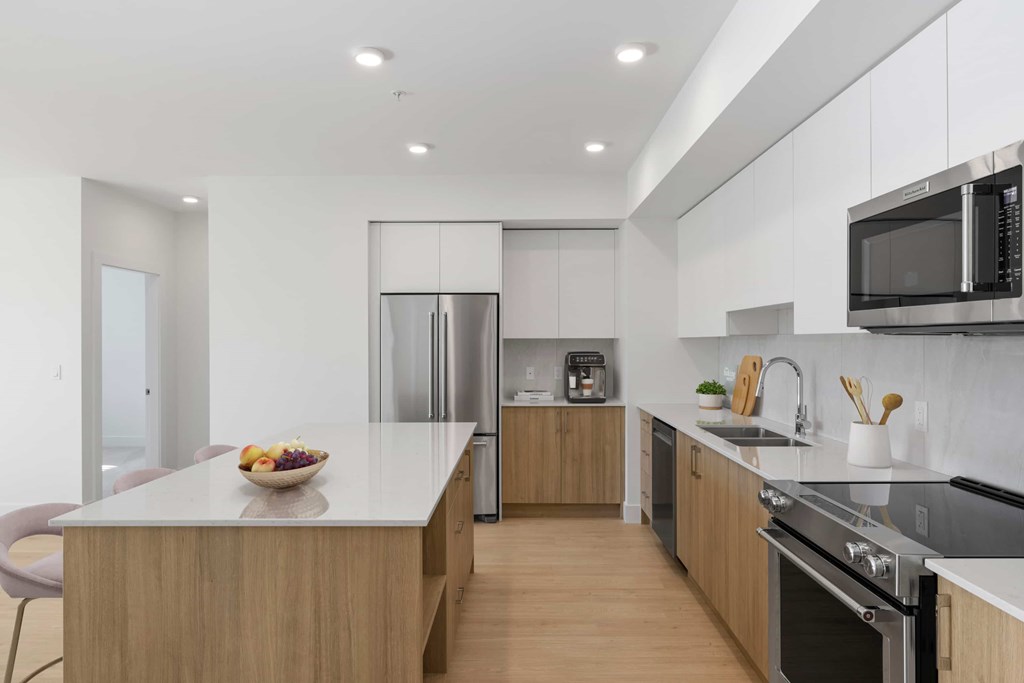 A modern kitchen with a wooden island and stainless steel appliances.