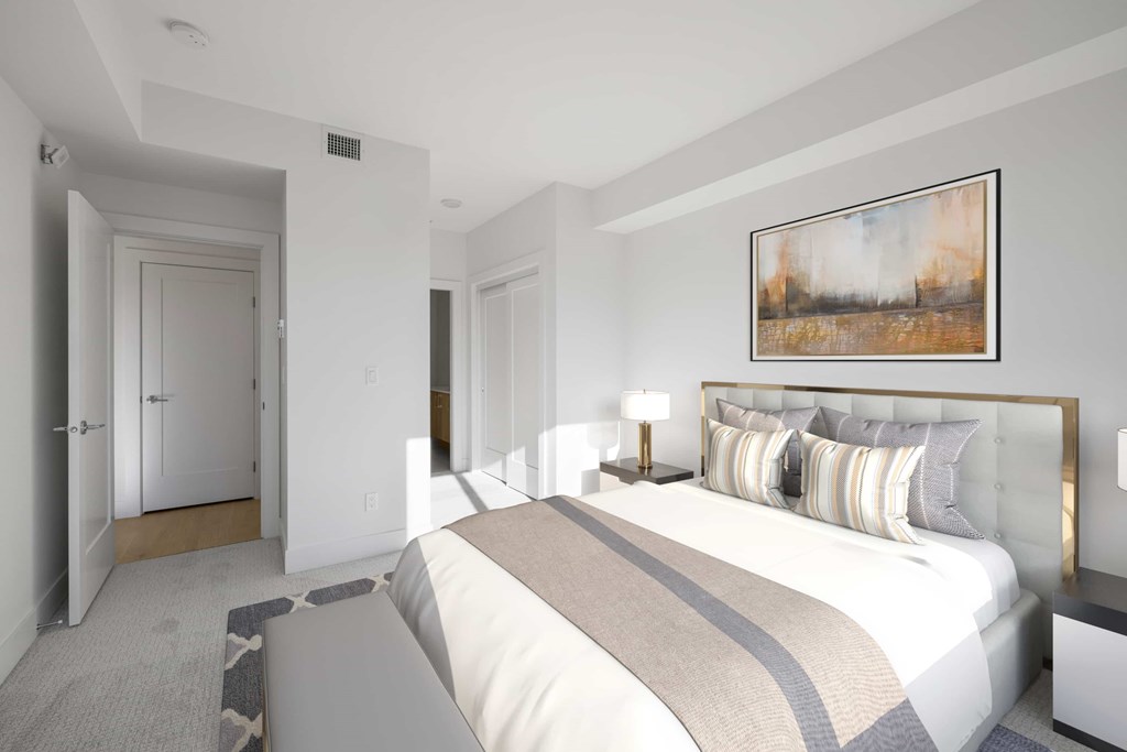 A bedroom with a large bed and a painting on the wall.