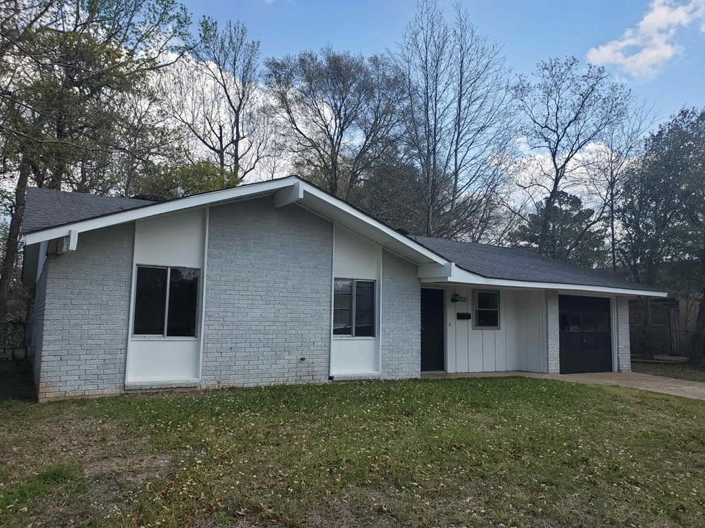 A house with a grey brick exterior and a white door.