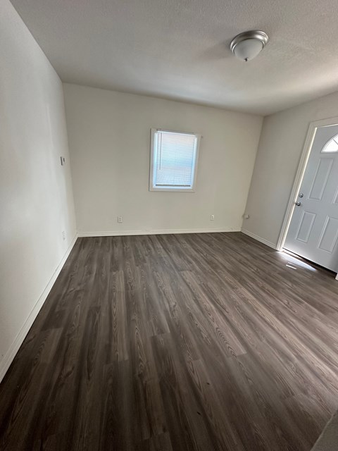 A room with wood flooring and a window.