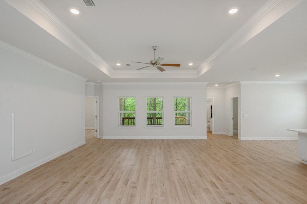 a living room with white walls and a ceiling fan