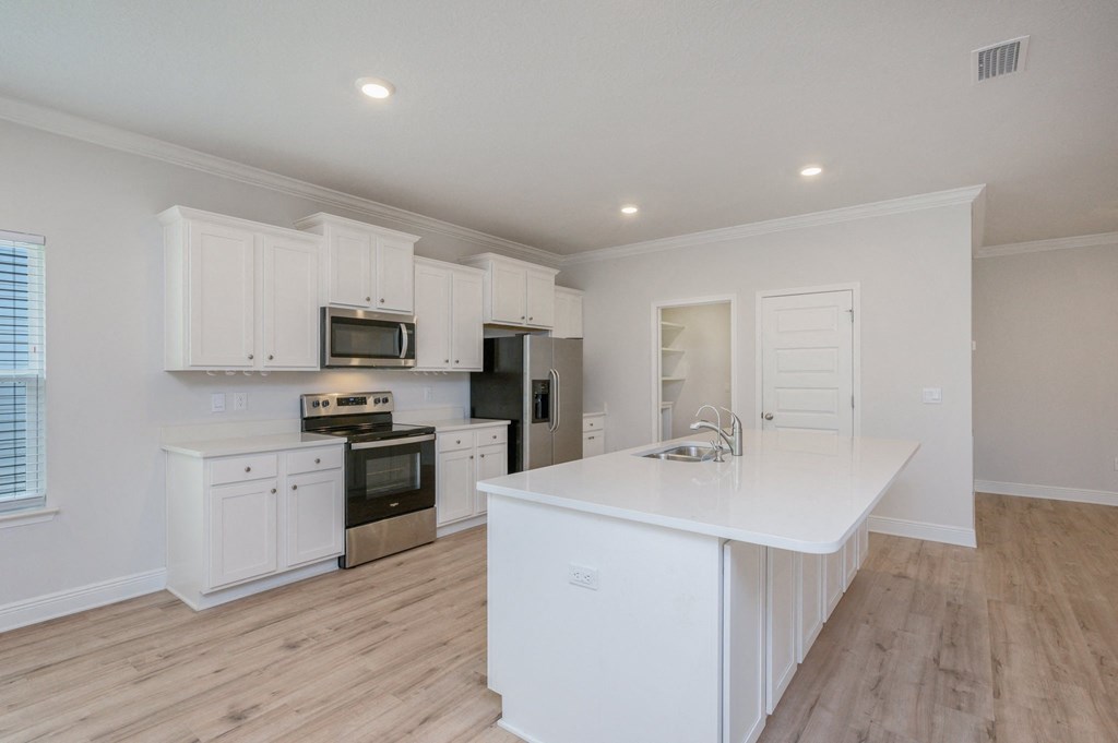 a kitchen with white cabinets and a white counter top
