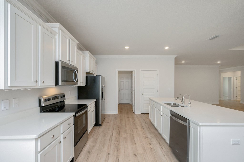 a kitchen with white cabinets and black appliances