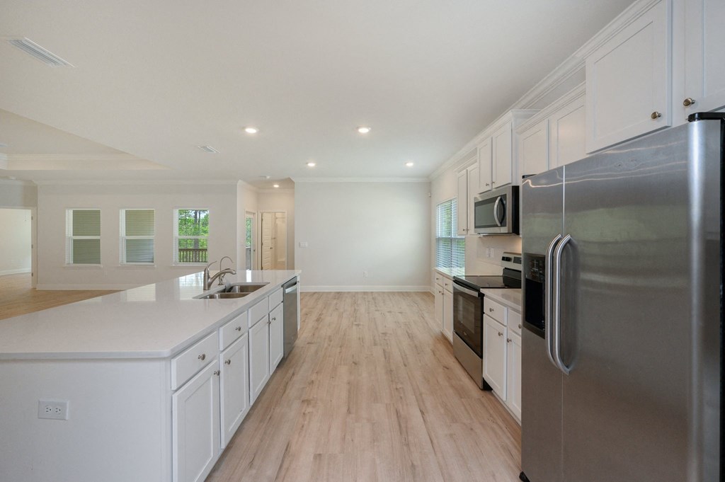 a large kitchen with white cabinets and stainless steel appliances