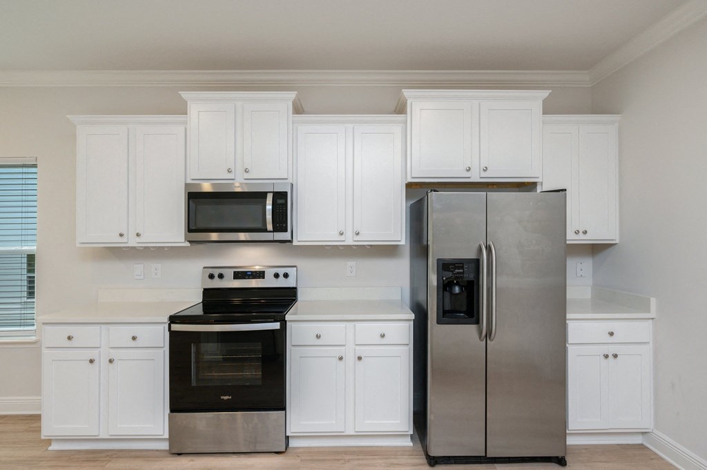 a kitchen with white cabinets and stainless steel appliances